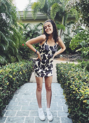 Kaleigh Bayoumy posing in a patterned summer dress.