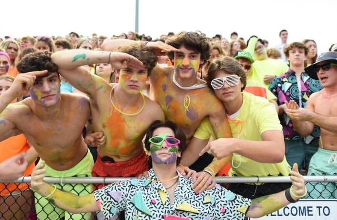 Patrick Downing standing with his student body at neon night.