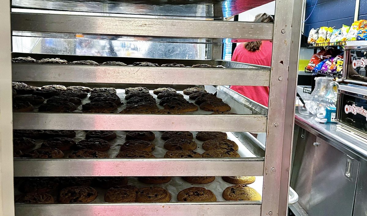 Trays of chocolate chip cookies are stacked on a huge rack in Hudson High School’s snack line. Tuesdays are the busiest days of the week when it comes to baking and selling cookies for Impiccini.
