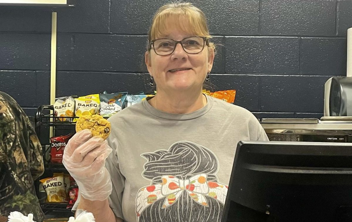 Snack line food preparer Debbie Impiccini holds up the most popular snack of Hudson High School: The chocolate chip cookie.