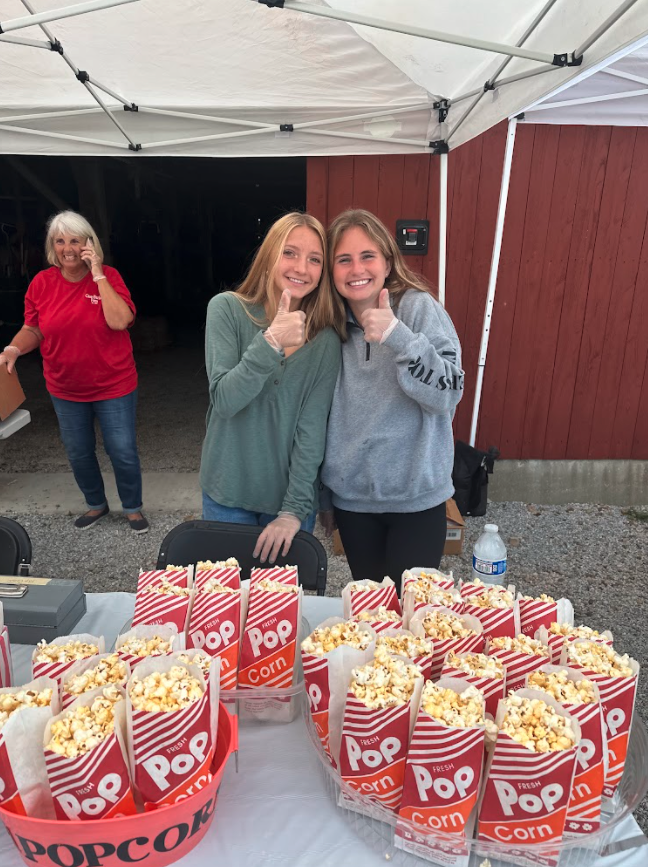 Natalie Muni and Katie Huber share a smile while volunteering at the Case Barlow Farm Fest. They were just two of the many Hudson Community First members working the fest.
