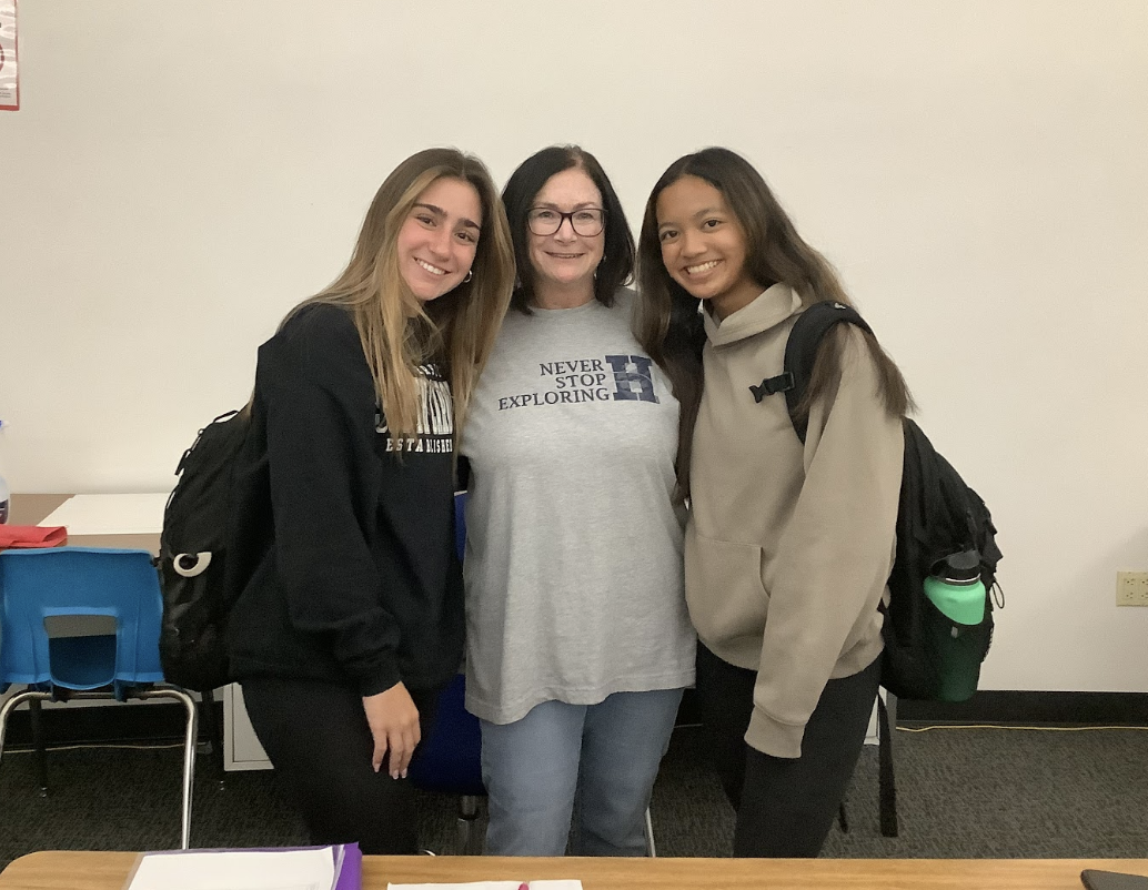 Jodi Siciliano, the study hall monitor at Hudson High School, with two students on a friday afternoon in the study hall room. Siciliano is showing spirit by wearing the Explorer U shirts on Adaptive Learning Day.
