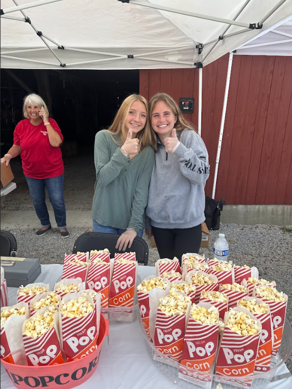 Natalie Muni and Katie Huber share a smile while volunteering at the Case Barlow Farm Fest. They were just two of the many Hudson Community First members working the fest.
