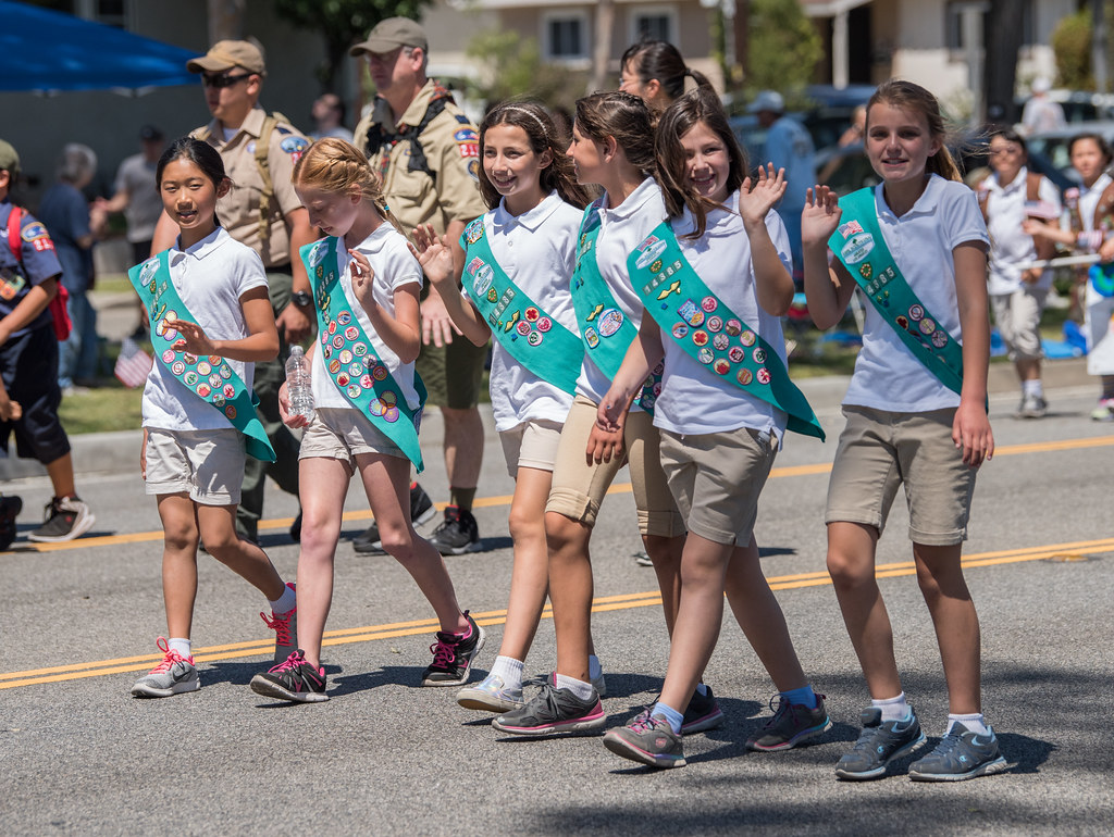 Young members of the Girl Scouts of the USA march in support of the organization during a parade. Boy and Girl Scouts of America by Mark Mauno is licened under CC by 2.0 Deed.