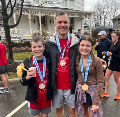 Sophomore Lucy Bechtel and family after the Frosty Five Mile in downtown Hudson Dec. 24, 2022. This run has become a tradition in the Bechtel family and they are looking forward to doing it again this year. 