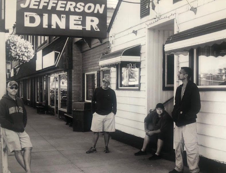 The band standing in front of their inspiration, the Jefferson Diner. From left to right, the teachers are Mr. McGowan, Mr. Carmichael, Mr. Mangol and Mr. Chorian.