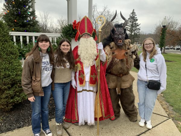 8th grader Zizi Moore, Junior Hanna Moore and Senior Ava Tallat-Kelpsa stand with St. Nicholas and Krampus on the second day of the Christkindlmarkt. Used with permission/Mike Piper of The Miracle League of Lake County.