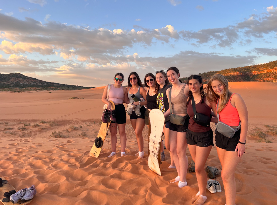 A group of Outdoor Society members pose with their boards after spending the evening on the pink sand dunes in Arizona. The club visited Zion, Bryce and Grand Canyon National Parks on this trip. Used with permission/Emily Goodman.
