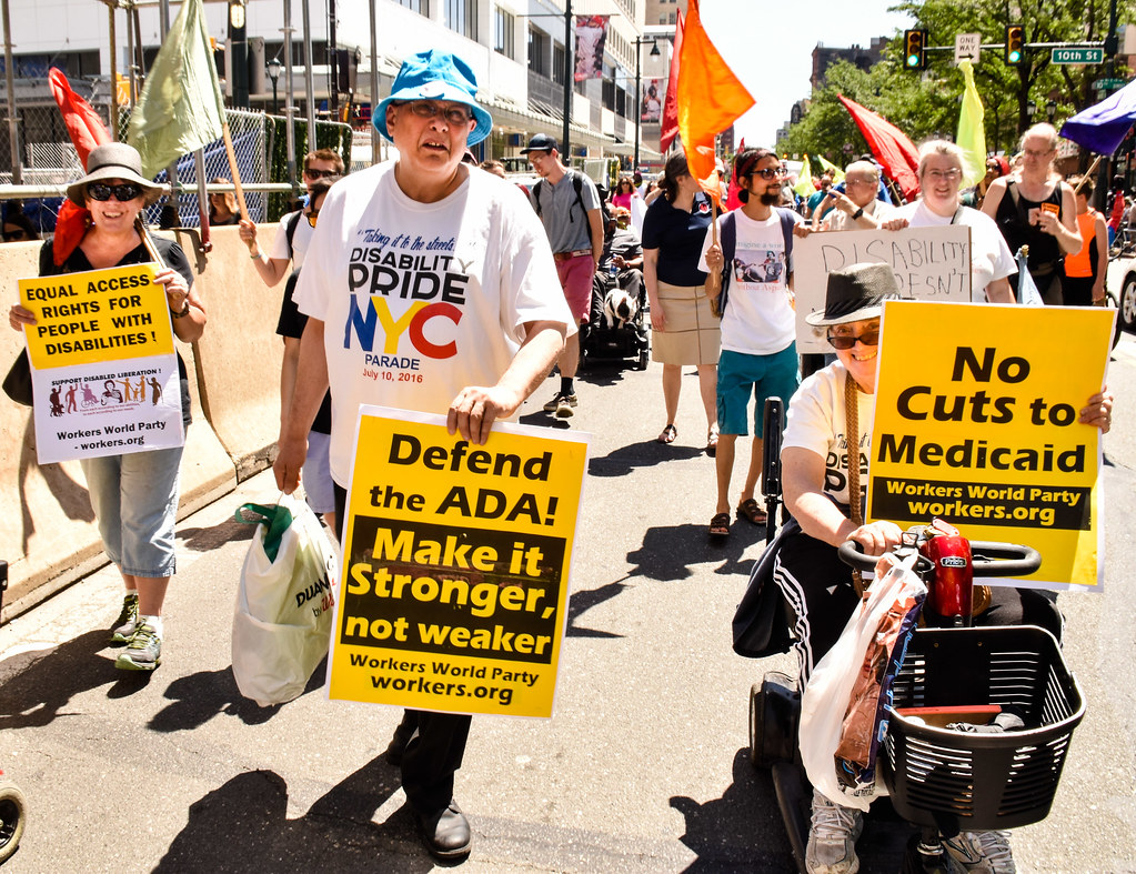 Disabled and abled individuals alike protest for disabled rights during a parade in Philadelphia. Philly Disability Pride March June 16 by Joe Piette is licensed under CC BY-NC-SA 2.0
