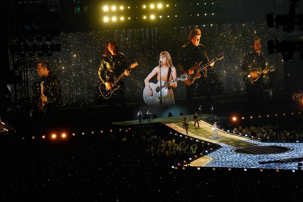 Taylor Swift performing at a stadium in Arlington, Texas, as part of her eras tour. Taylor Swift by Ronald Woan is licensed under CC BY-NC 2.0. 