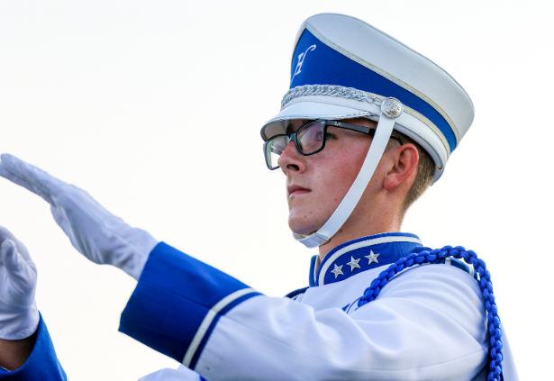 Senior Jack McCormick conducts the Hudson High School Alma Mater during a football game. This year, McCormick is the band's senior squad leader. 