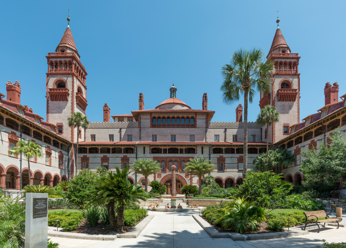 The Ponce de León Hotel at Flagler College showing off its gorgeous palm trees and orange detailing on a bright day in St. Augustine, Florida.