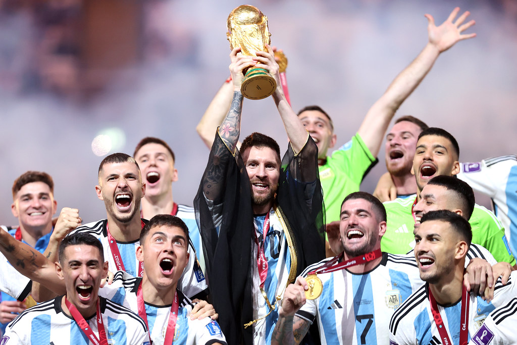 Lionel Messi holds up the World Cup trophy with his team after winning the final. Argentina won the 2022 World Cup over France in penalty kicks.